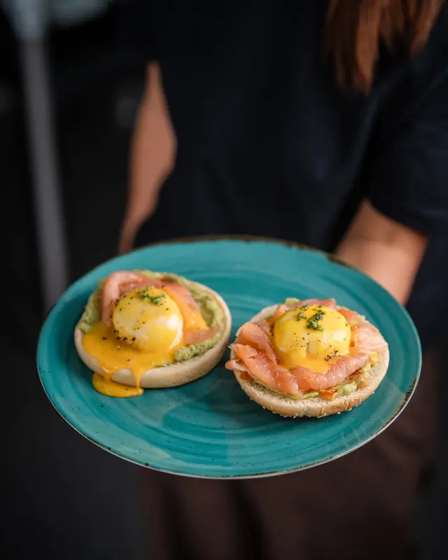 Two eggs Benedict on a teal plate